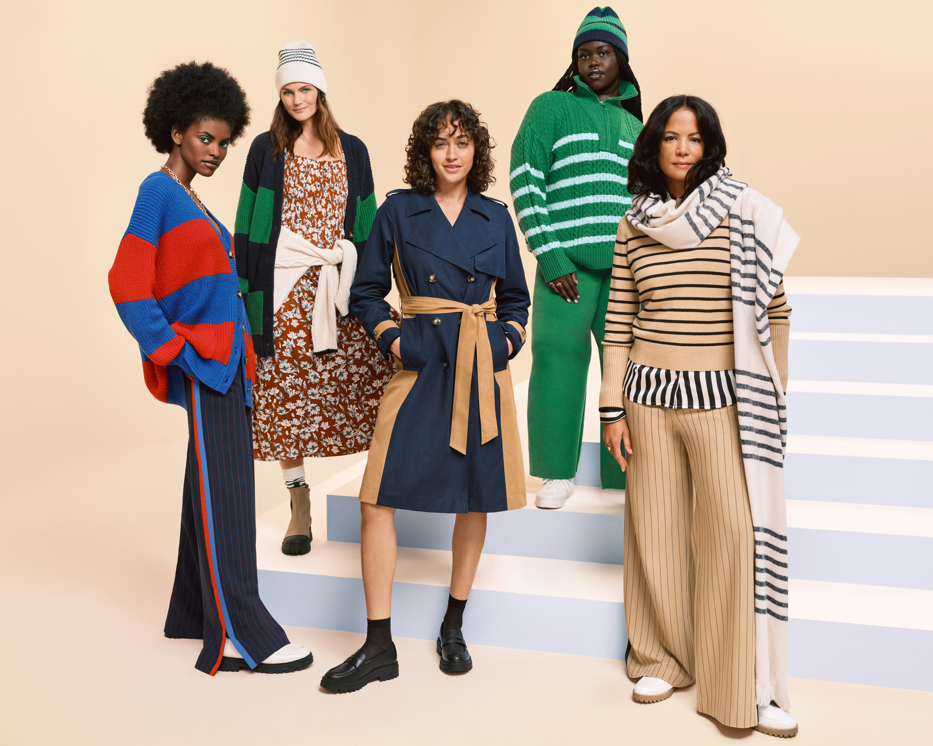 Five models stand on steps wearing multicolored stripes.