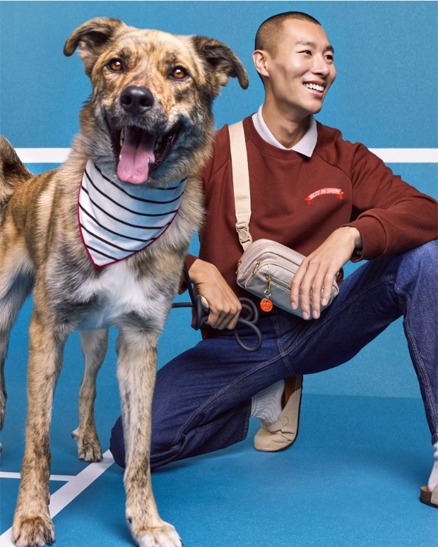 A model poses with a dog wearing a bandana from The Cuddle Collab collection.