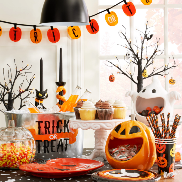 A tablescape of Halloween decorations, candy and snacks.