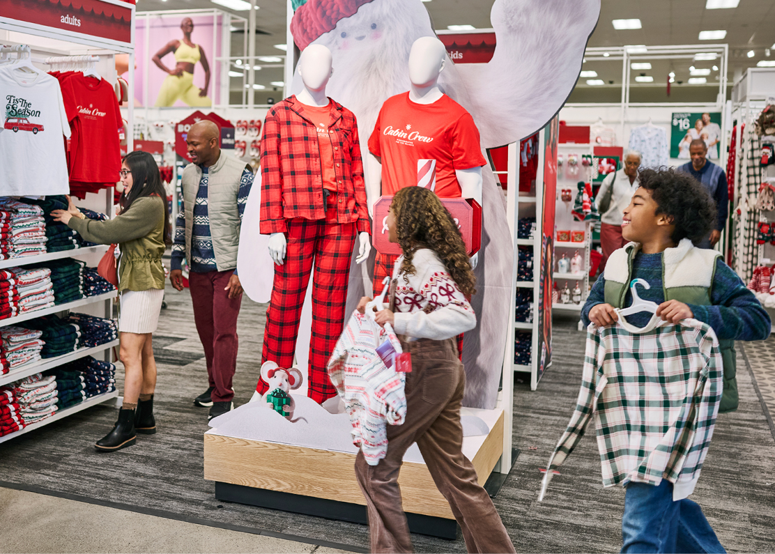 Shoppers in a Target store pass by two mannequins wearing pajamas.