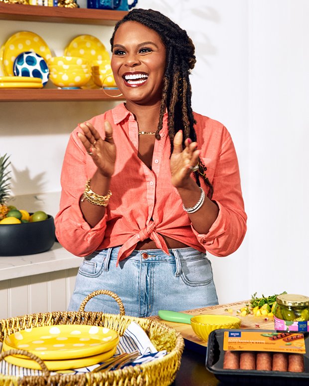 a woman smiling and holding her hands up