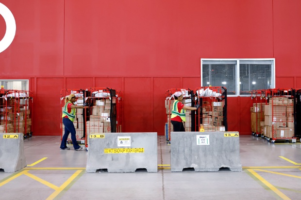 Two team members push racks of orders for drivers.