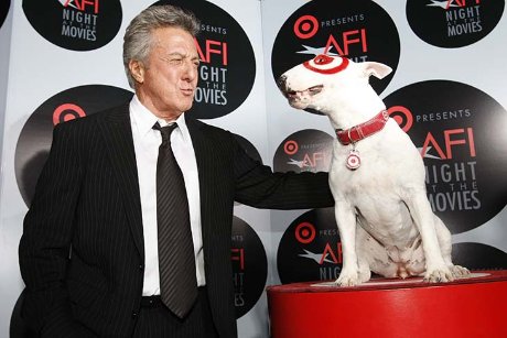 a man in a suit and tie with a dog on a red box