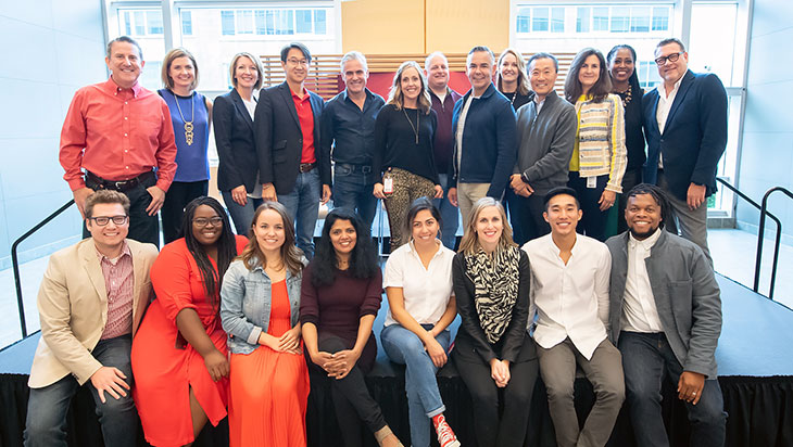 group of leaders and team members pose on a stage