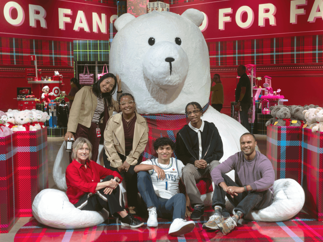 Target team members pose in front of an oversized stuffed teddy bear