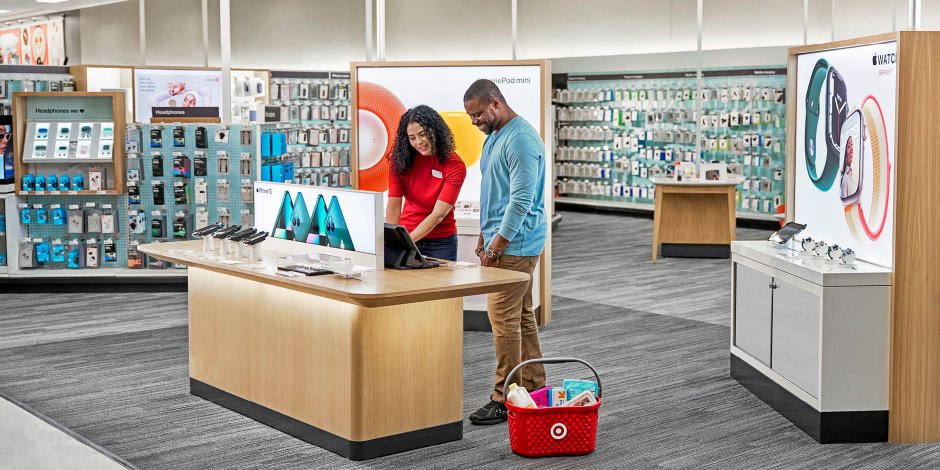 a man and woman standing next to a counter with a computer