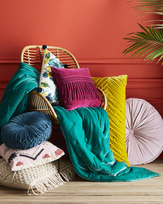 Throw pillows and blankets on a wooden chair