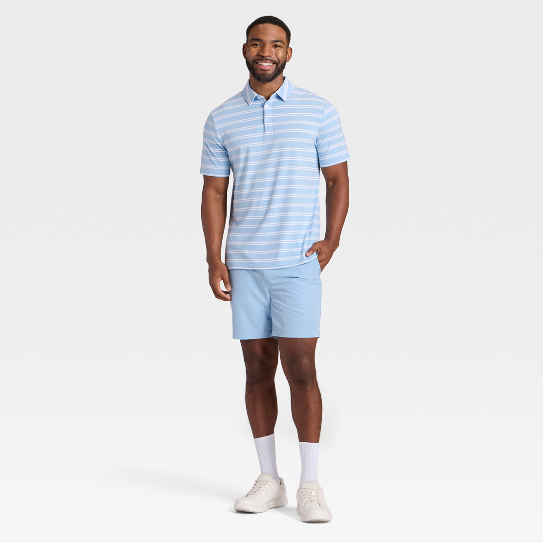 A model wearing a light blue and white striped polo shirt and light blue shorts from Goodfellow &  Co.