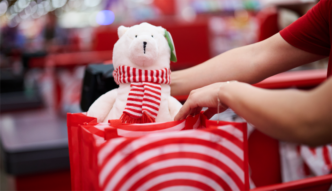 A toy polar bear is placed inside a Target reusable bag by a team member.