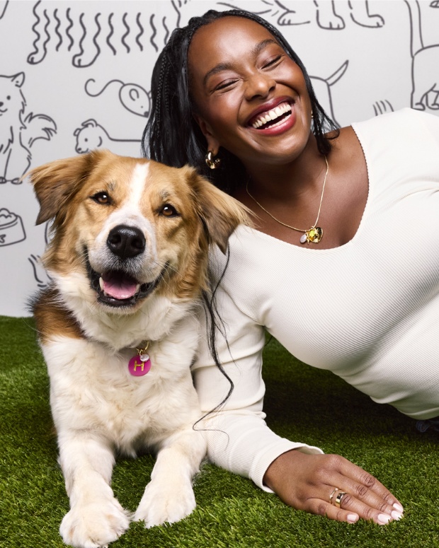 A model and a dog pose wearing matching charms from The Cuddle Collab collection.