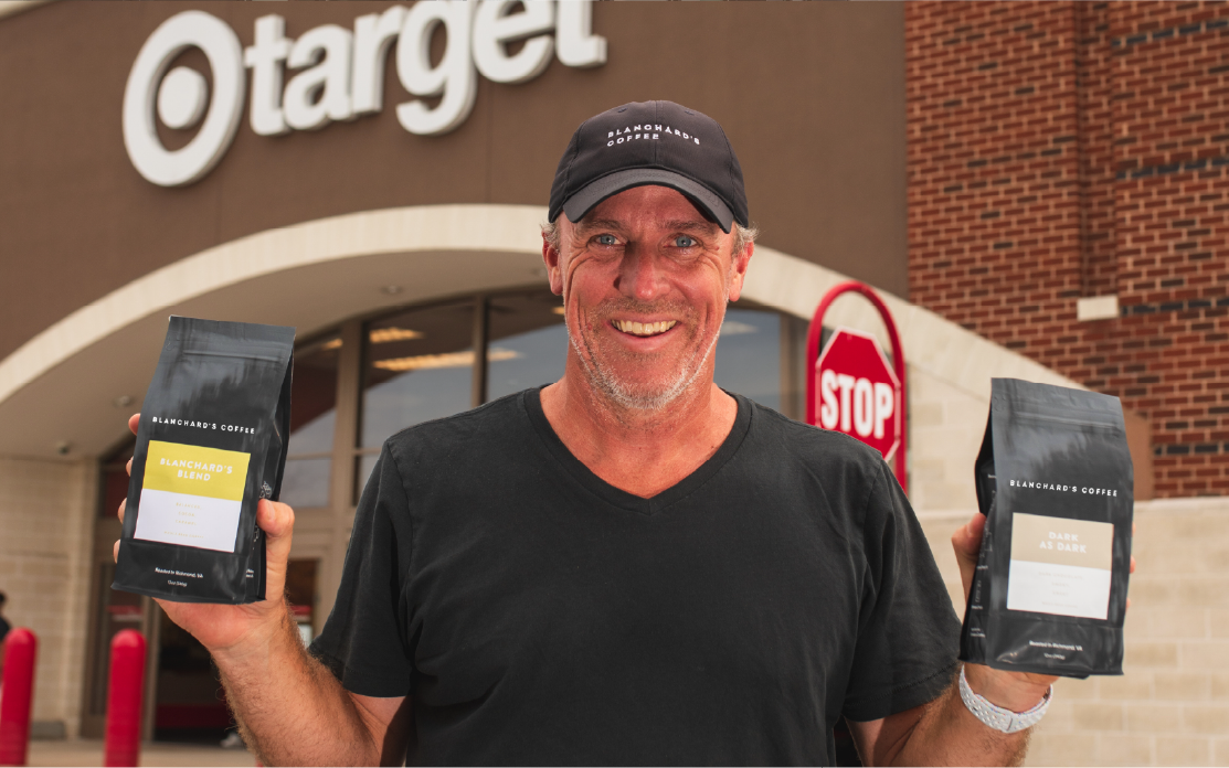Blanchard’s Coffee founder poses with his coffee in front of Target store.