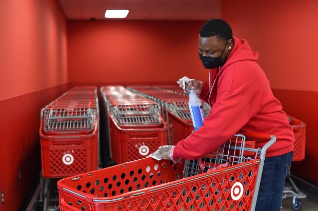 a man in a red coat pushing a shopping cart with a bag