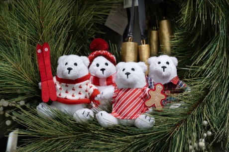 Four mini plush Berry the Bears are sitting on holiday greenery.