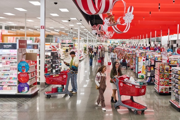 Wide view of a decorated holiday aisle with candy cane ceiling décor and shoppers pushing red carts.