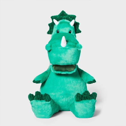 A white background displays a bright green dinosaur stuffed animal with tiny horns.