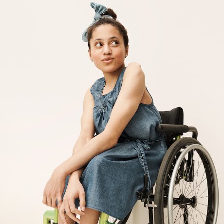 a woman in a dress sitting in a wheelchair