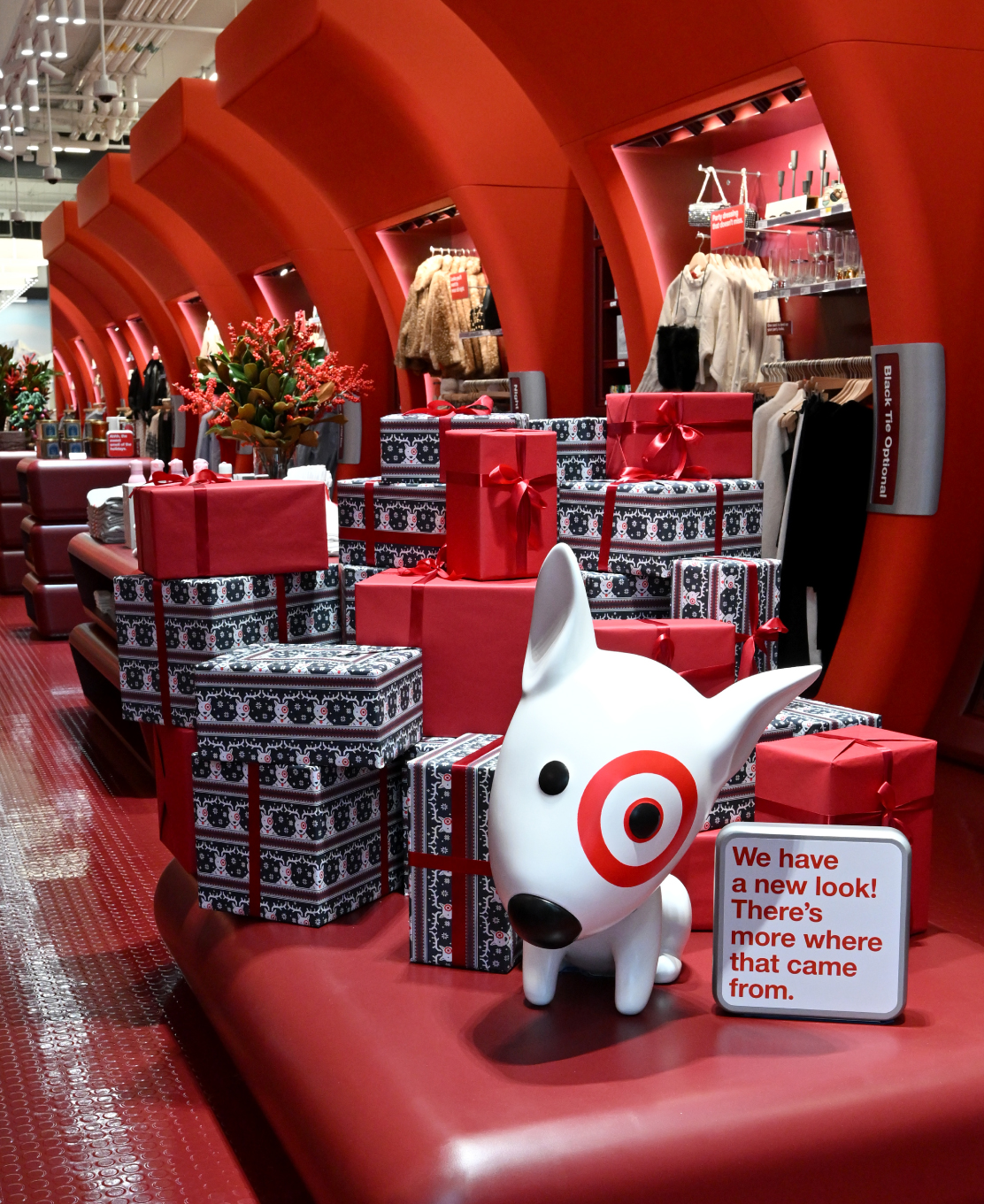 A toy Bullseye dog on a red surface in front of wrapped holiday gifts at the Target SoHo store.
