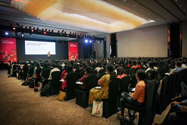 a group of people sitting in a room with a screen and a projector screen