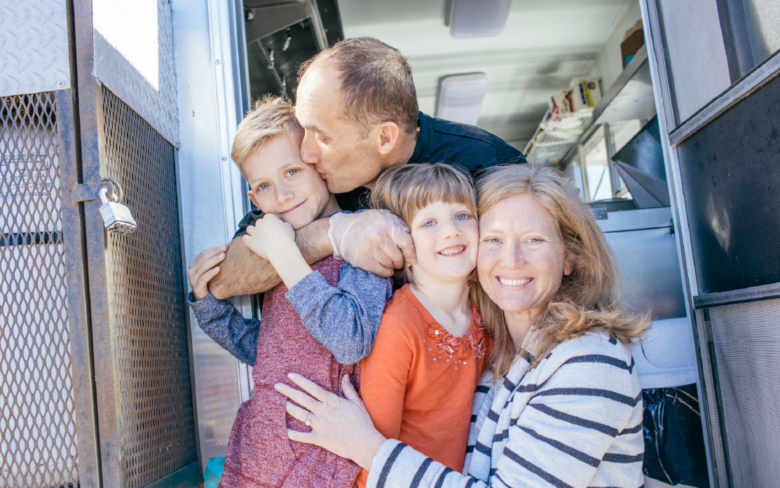 A family poses and smiles for a photo.