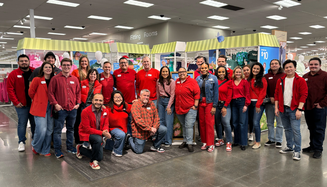 Michael Fiddelke smiles for a photo with Target team members in a store.