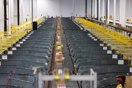 A conveyor carries boxed packages for sorting. 