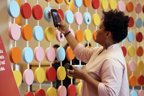 a person taking a picture of a wall of balloons