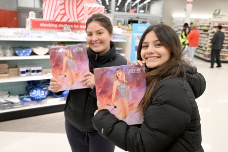 Two fans show off their copies of “Taylor Swift | The Eras Tour Book” inside a New Jersey Target store on Black Friday