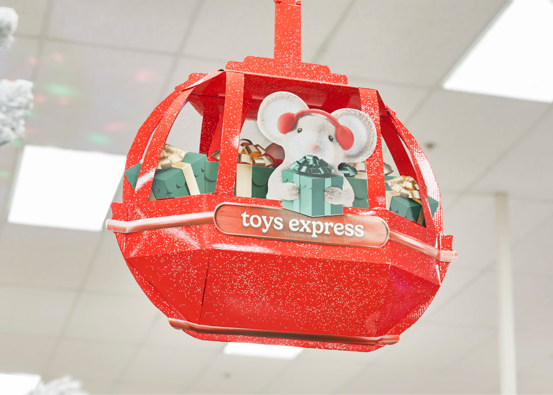 A red gondola with the words “Toys Express” and a mouse holding a present hangs from the ceiling of a Target store.