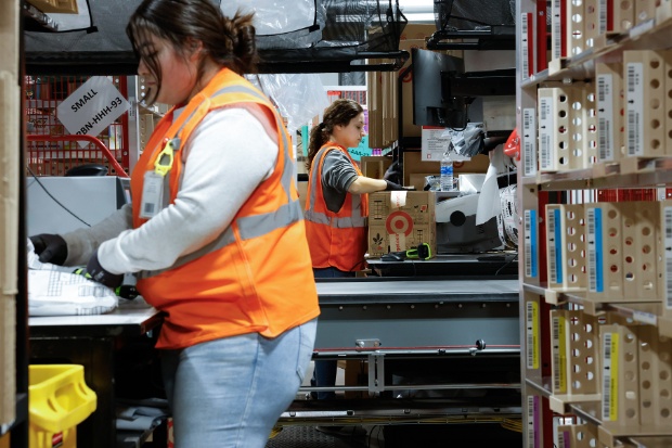 Two team members wearing vests package orders.