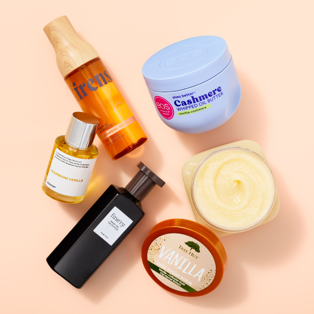 A variety of beauty products on a peach-colored background.