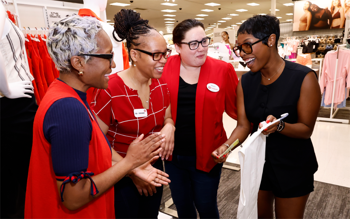 Jeneé Naylor shows three Target team members an item from her Future Collective collection.