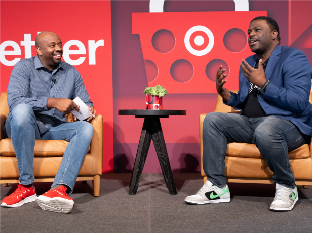 Ron Brown, vice president of community impact, and Artis Stevens, president and CEO of Big Brothers Big Sisters of America, sit together on stage during a Target event, discussing the partnership between Target and BBBS.