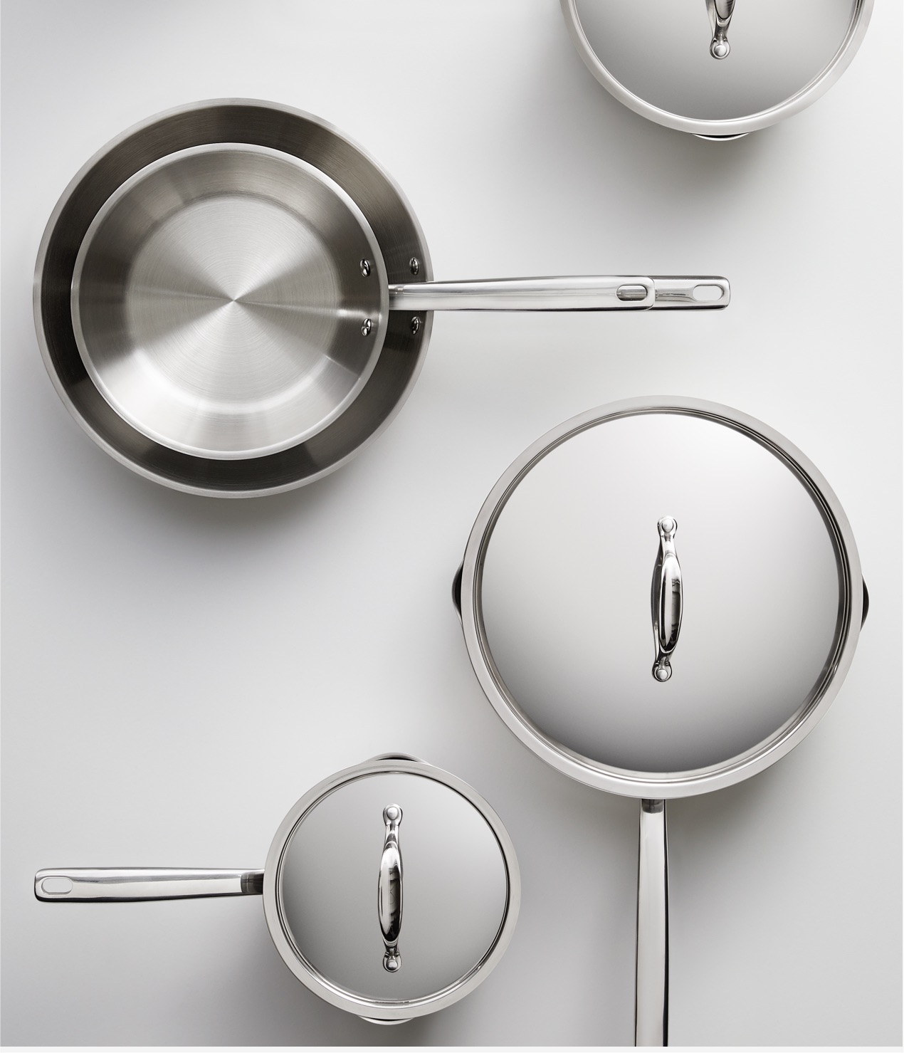 A variety of covered and uncovered stainless steel cookware