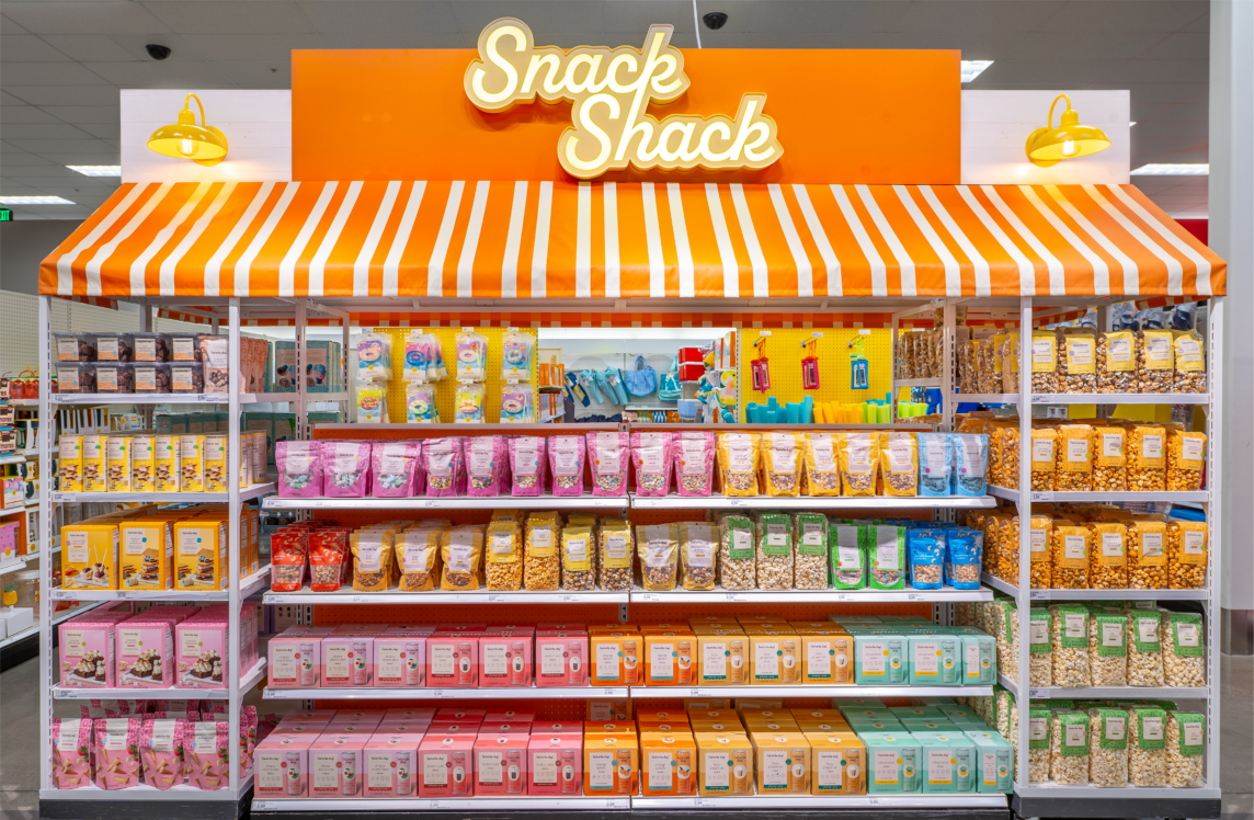 Target’s summer Snack Shack area featuring colorful snack options in an orange and white cabana-striped display area.