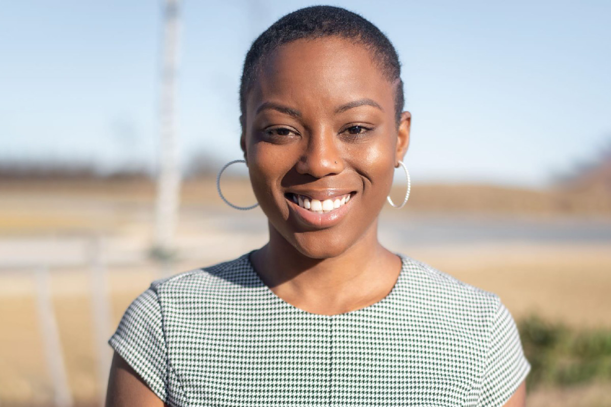 A photo of Neshonia standing outside and smiling.