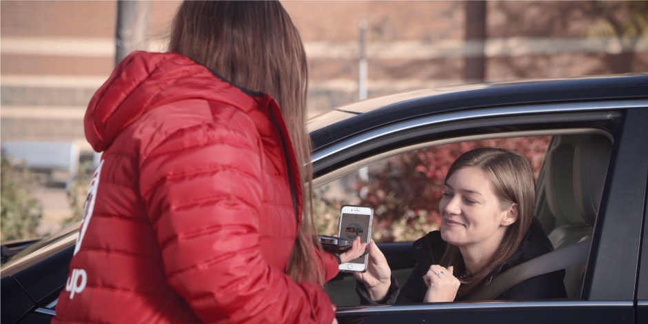 a person taking a picture of a person in a car