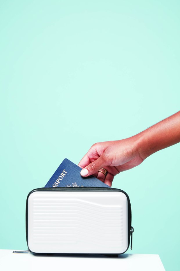 a hand holding a laptop