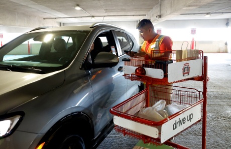 A Target team member is delivering a Drive Up order to a guest in a car.