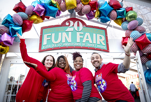 a group of people posing for a photo in front of a sign