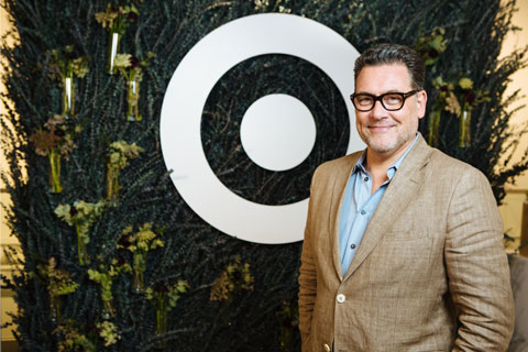 Mark Tritton smiles in front of greenery and a white bullseye