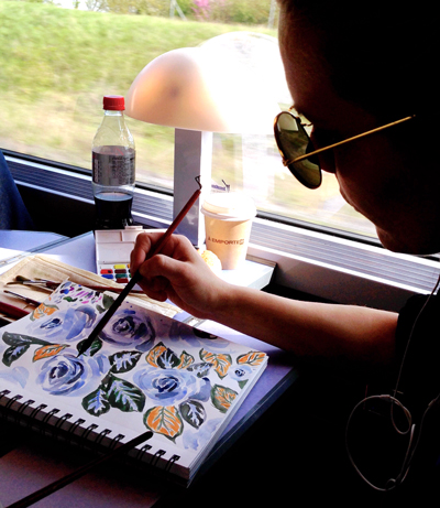 An artist paints on a train