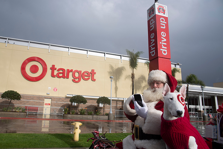 Santa and Bullseye sit in a sleigh in Target's parking lot