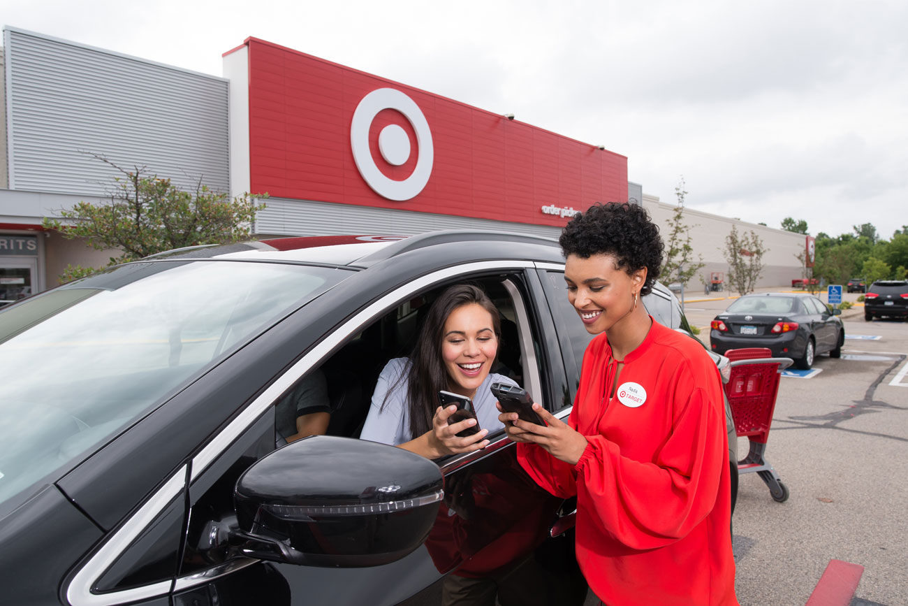 A team member brings a guest's order to her car