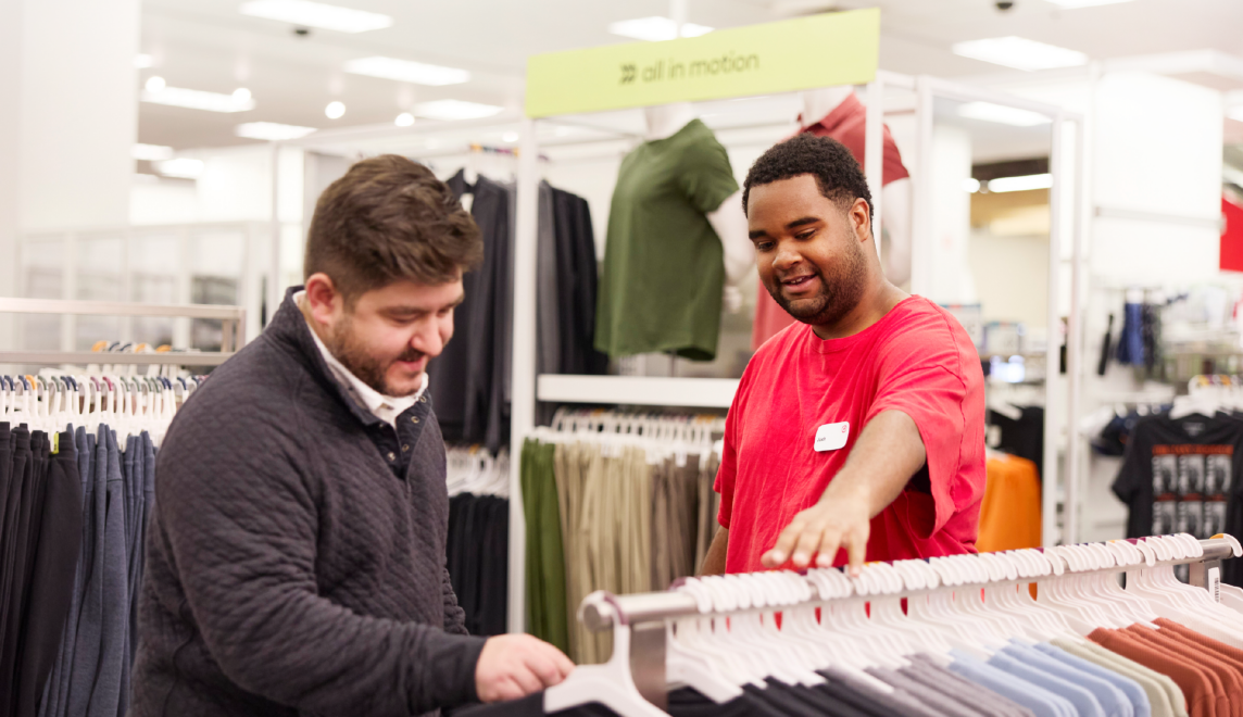 A team member helps a guest as they browse apparel at Target.