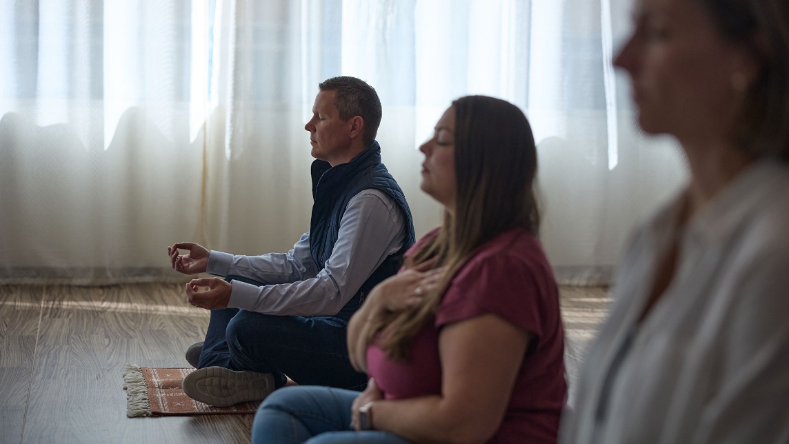 A group of people sitting on the floor meditating.