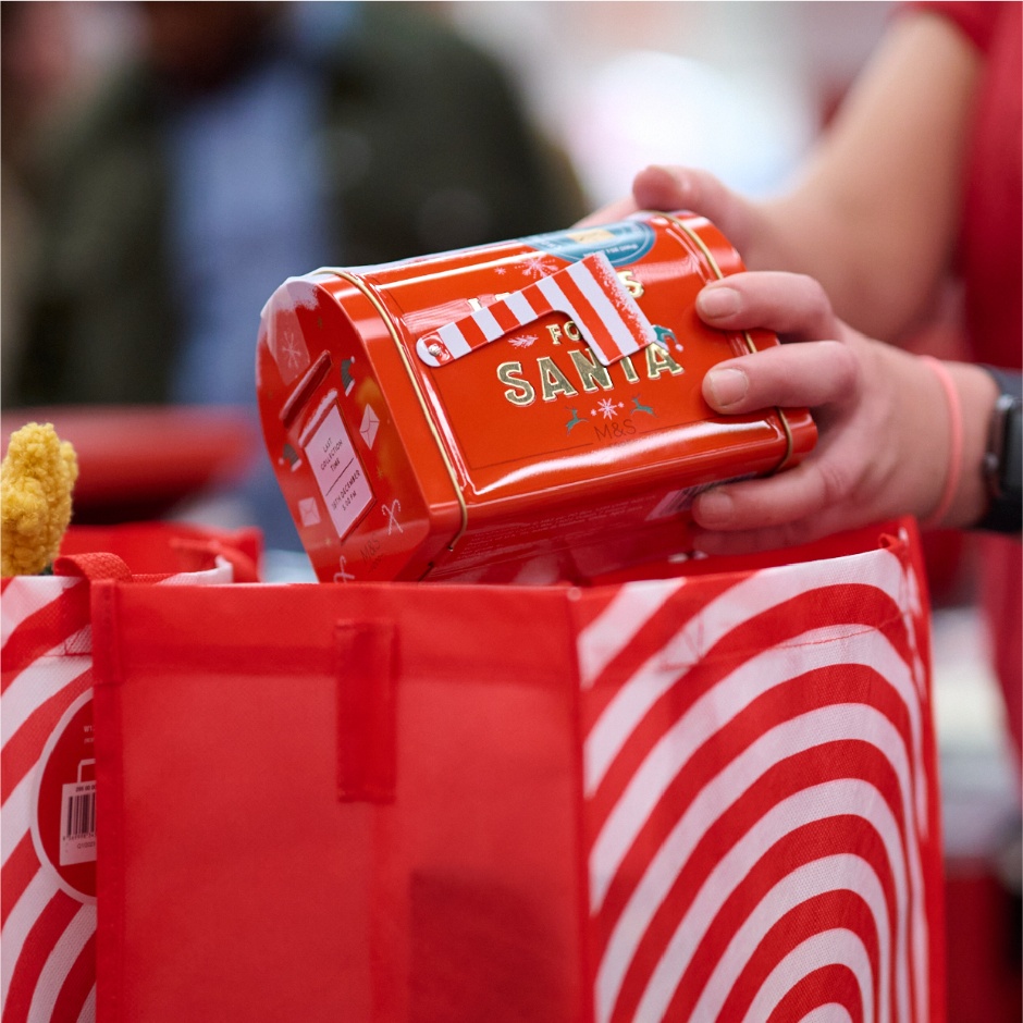 A team member places a novelty Santa’s mailbox into a Target reusable bag.