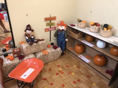 a room with a table and shelves with pumpkins and a doll