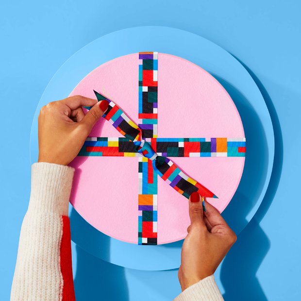 hands holding a colorful cube