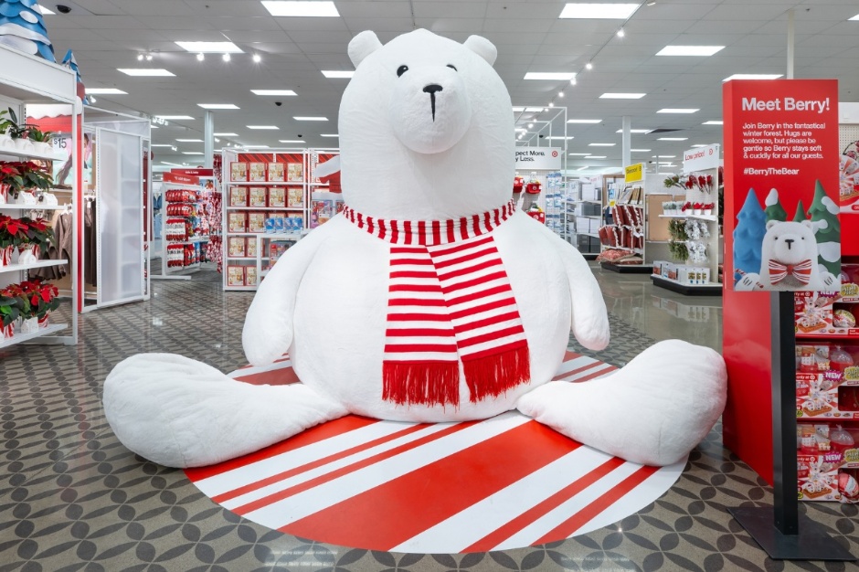 A nine foot tall white plus bear sits on the floor of a Target store.