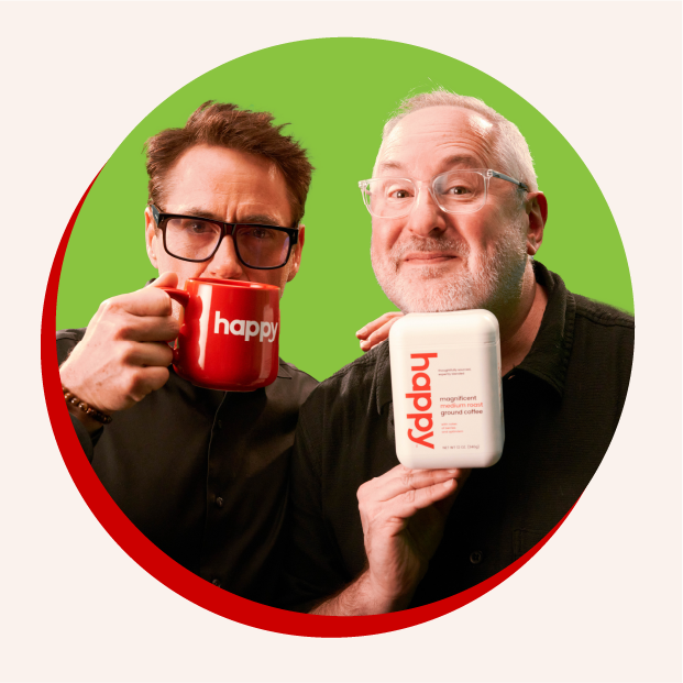 Robert Downey Jr. Holding a red coffee mug that says ‘happy’ and Craig Dubitsky holding a white container of happy coffee.